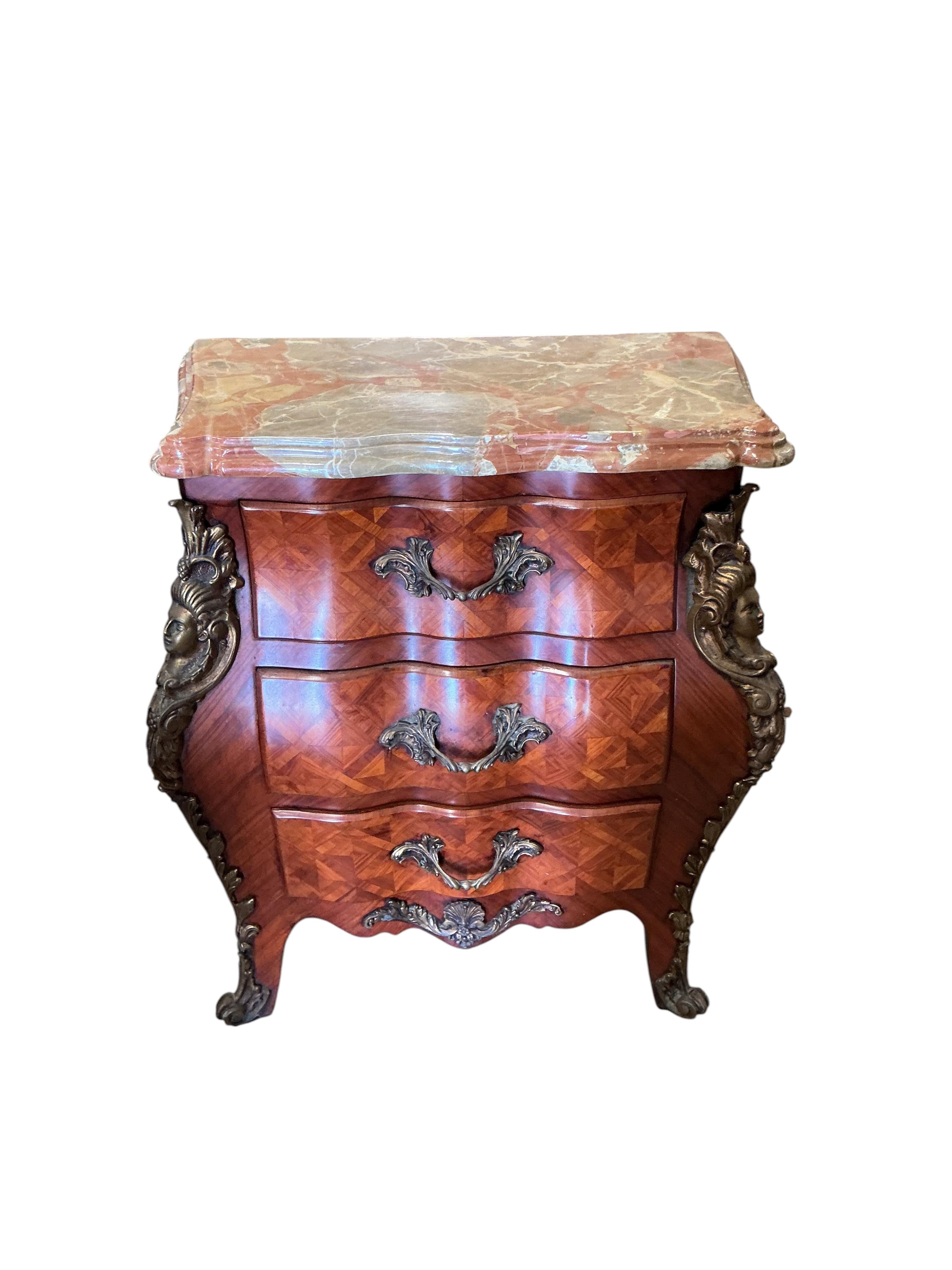 A pair of French transitional style bombe gilt metal mounted onyx top three drawer bedside chests, width 61cm, depth 33cm, height 71cm